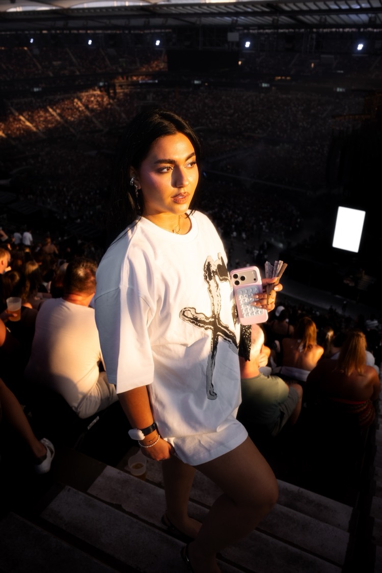 Im Stadion, weißes Shirt, Menge und Flutlicht im Hintergrund.