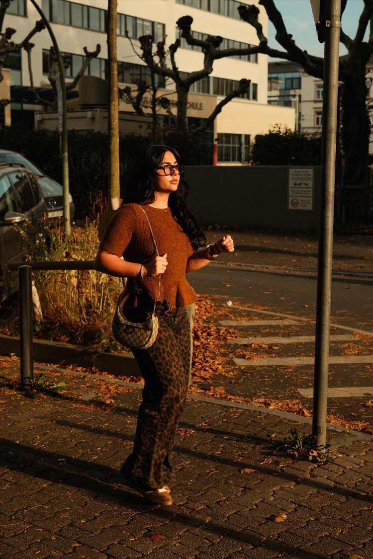 Straße im Herbstlicht, Bäume und Bürobauten, sie kommt entgegen.